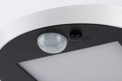 Close-up of white and black LED ceiling light with motion sensor and on/off switch
