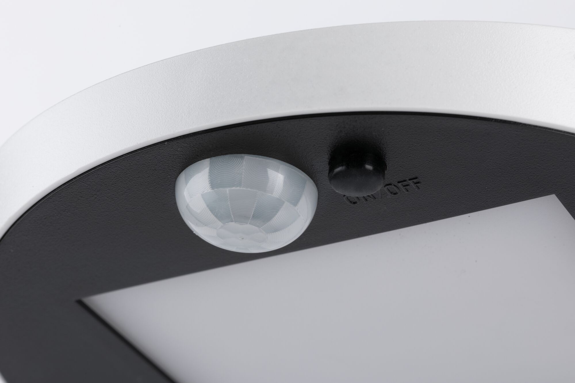 Nahaufnahme eines weißen und schwarzen LED-Deckenlichts mit Bewegungsmelder und Ein-/Ausschalter