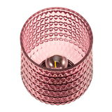 Pink glass tealight holder with textured pattern and visible candle flame for decorative lighting