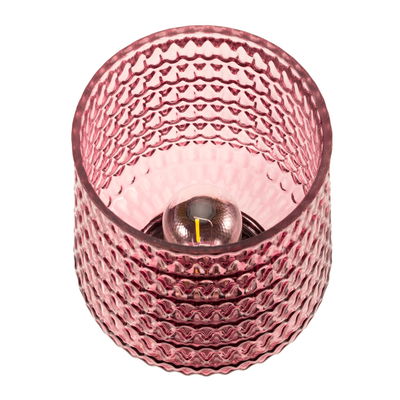 Pink glass tealight holder with textured pattern and visible candle flame for decorative lighting