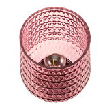 Pink glass tealight holder with textured pattern and visible candle flame for decorative lighting