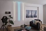 Modern living room with white and blue LED wall lights, black armchair, and cityscape pictures.