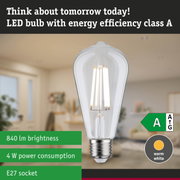 Clear LED bulb with warm white light and ultra-efficient energy use against green forest background
