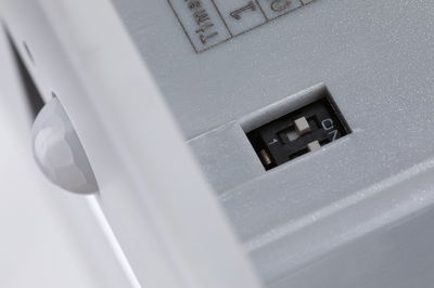 Close-up of white plastic housing with switch and sensor ball for lighting technology