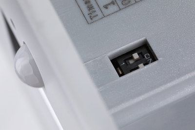 Close-up of white plastic housing with switch and sensor ball for lighting technology