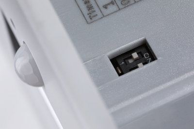 Nahaufnahme eines weißen Kunststoffgehäuses mit Schalter und Sensorkugel für Beleuchtungstechnik