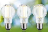 Three clear glass LED bulbs with warm white light, energy-efficient lighting for home use.