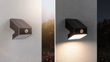 Black solar wall light with motion sensor, off by day, warm white light at night for outdoor use