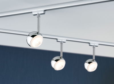 Drie ronde chromen LED-spotlights op railsysteem voor moderne kamerverlichting