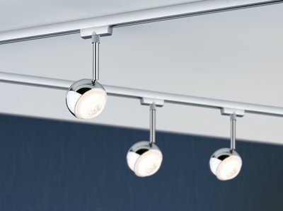 Drie ronde chromen LED-spotlights op railsysteem voor moderne kamerverlichting