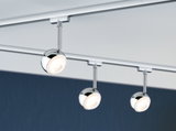 Three round chrome LED spotlights on track system for modern room lighting