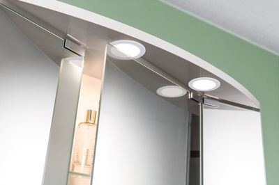 Round white LED mirror lights with warm white illumination for bathroom cabinet lighting.
