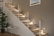 Modern staircase with wooden steps and white LED wall lights providing ambient hallway lighting