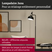 Lampadaire noir Juna avec abat-jour réglable à côté d'œuvres murales abstraites dans un salon moderne