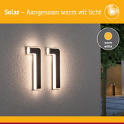 Zonne-energie huisnummer met warm wit licht op grijze muur, modern buitenverlichtingsontwerp