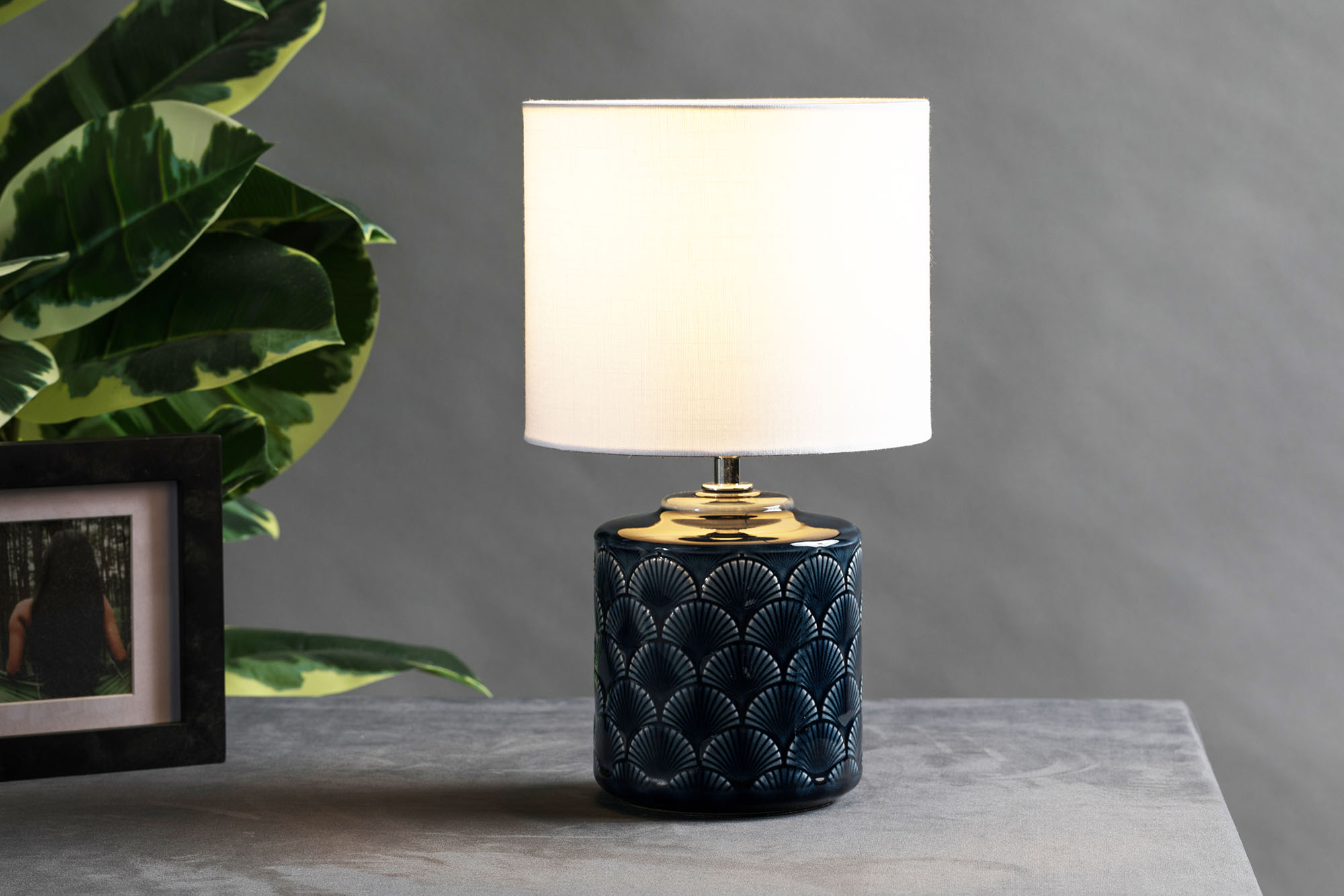 Table lamp with dark blue ceramic base and white fabric shade for elegant home lighting