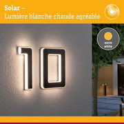 Numéro de maison solaire avec lumière LED blanc chaud sur mur gris pour éclairage extérieur