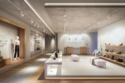 Boutique de mode moderne avec éclairage mural blanc et étagères en bois clair pour chaussures et sacs