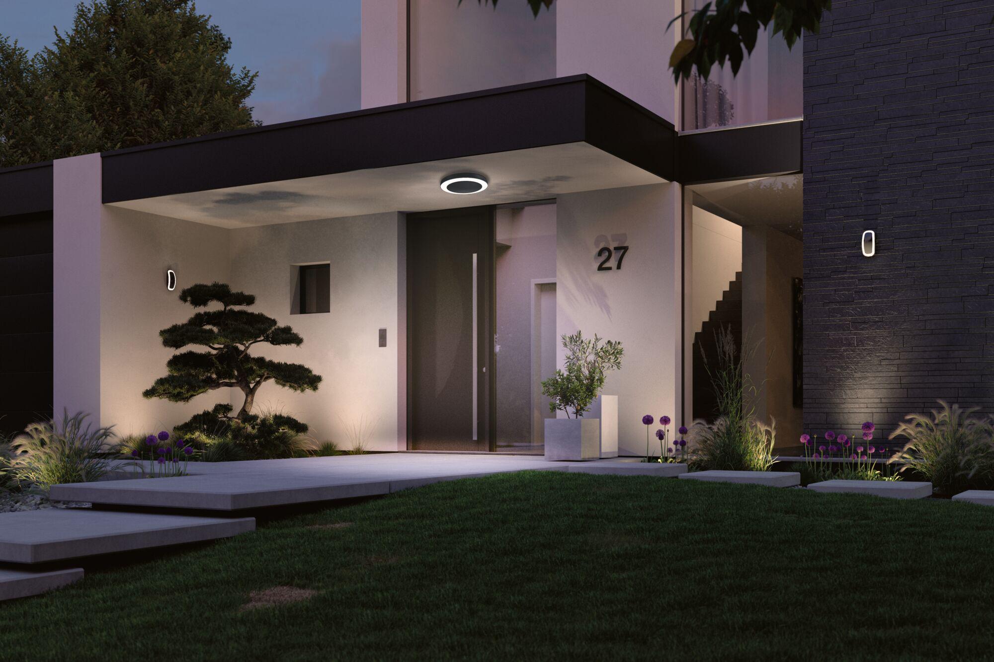 Modern outdoor lighting with black LED ceiling light and wall lamps on white house with garden.