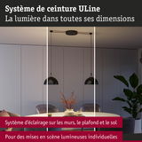 Système d'éclairage ULine avec suspensions noires au-dessus d'une table ronde dans un salon moderne