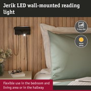 Black metal Jerik LED wall light with warm white glow and 3-step dimmer beside bed and wooden wall