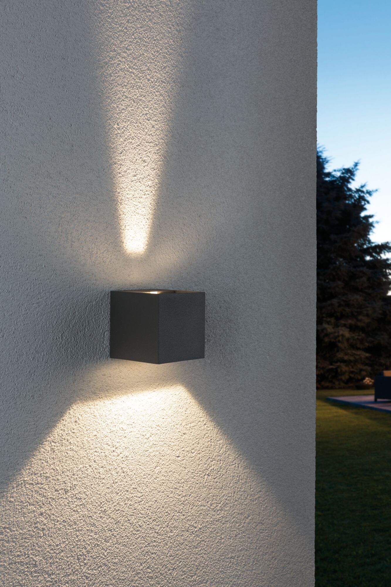 Black square outdoor wall light in metal with warm white up and down lighting effect.