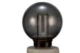Round smoked glass bulb with visible filament on grey stone base for decorative lighting use.