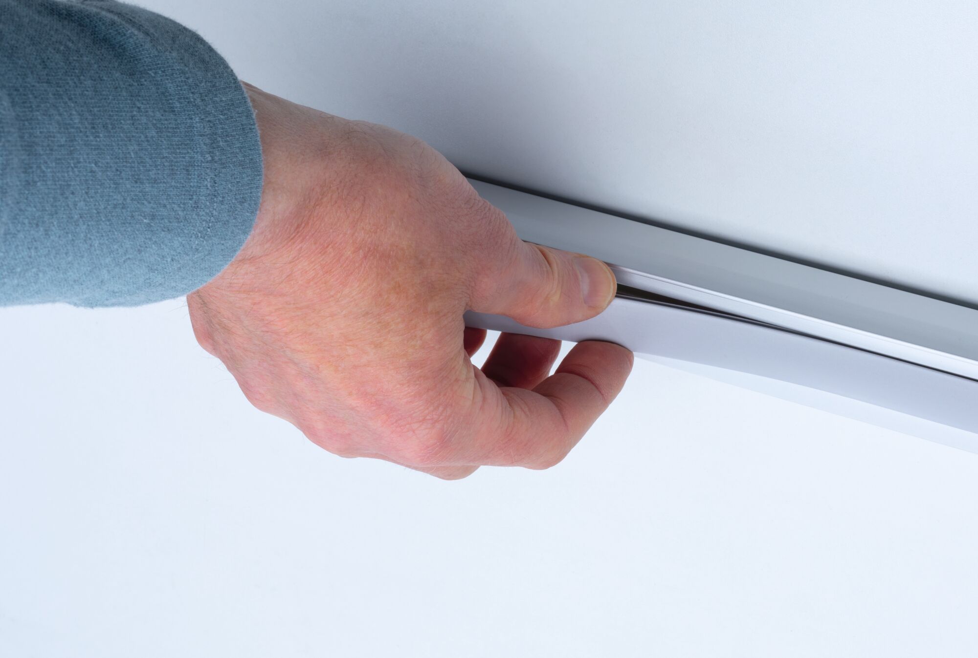 Hand hält grauen flexiblen LED-Lichtstreifen mit weißem Diffusor für moderne Raumbeleuchtung