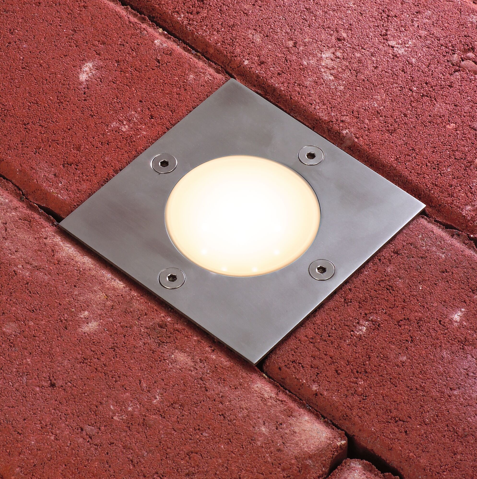 Eingelassene LED-Bodenleuchte aus Edelstahl mit warmweißem Licht in rotem Pflasterstein