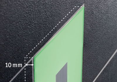 Nahaufnahme einer schwarzen Oberfläche mit grünem, 10 mm dickem Material und grauem Streifen