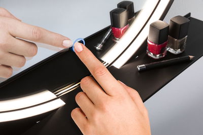 Zwart LED-spiegellichtpaneel met touchschakelaar en rode, bruine nagellak voor make-up verlichting