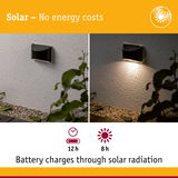 Black solar wall light on white wall with 12h runtime and 8h charging via solar radiation for outdoor use