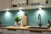Moderne Küche mit dreieckigen LED-Unterbauleuchten in Weiß über Holzarbeitsplatte und Spüle