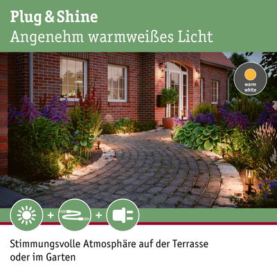 Außenbeleuchtung mit warmweißem Licht entlang eines gepflasterten Gartenwegs mit Pflanzen.
