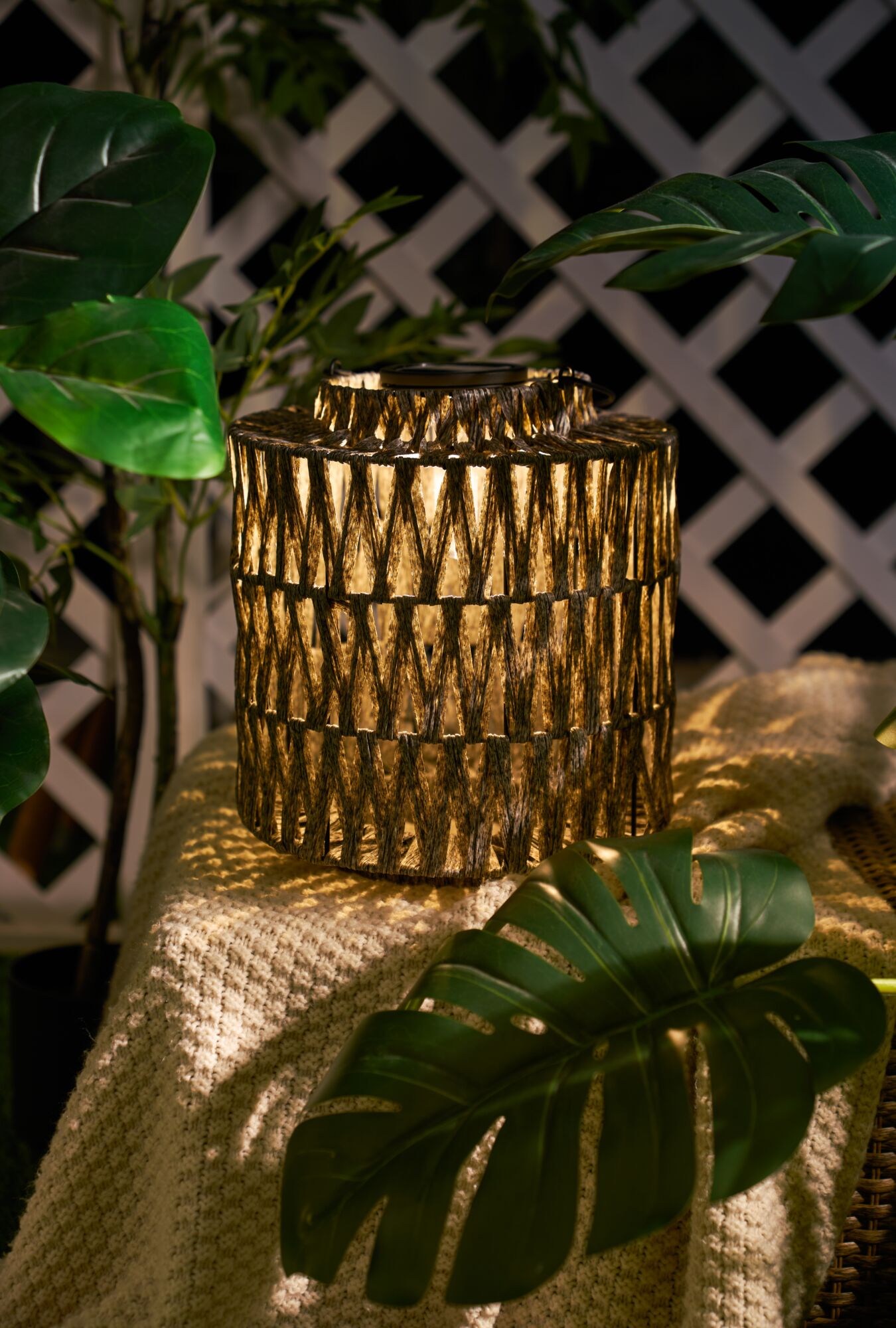 Lanterne solaire décorative en matériau naturel tressé marron pour jardin et terrasse.