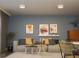 Modern living room with grey sofa, yellow cushions, blue walls, and two round ceiling lights.