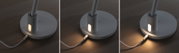 Grijze ronde lampvoet met ingebouwd warm wit LED-licht en aangesloten stoffen kabel op houten tafel