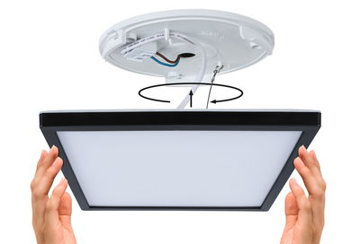 Installation of square LED ceiling panel light with black frame and white diffuser surface.