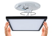 Installation d'un panneau LED carré pour plafond avec cadre noir et diffuseur blanc.