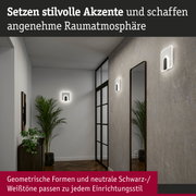 Moderne weiße LED-Wandleuchten mit geometrischem Design in Flur mit Spiegel und Pflanzen