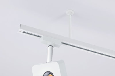 Weißer LED-Schienenstrahler aus Metall an weißer Decke montiert für moderne Innenbeleuchtung