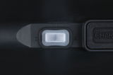 Close-up of white plastic switch on black casing with charging port next to it