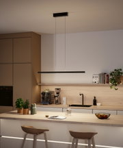 Modern black metal LED pendant light above kitchen island with wooden countertop