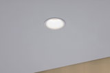Round white LED recessed light in ceiling with warm white glow for modern indoor lighting