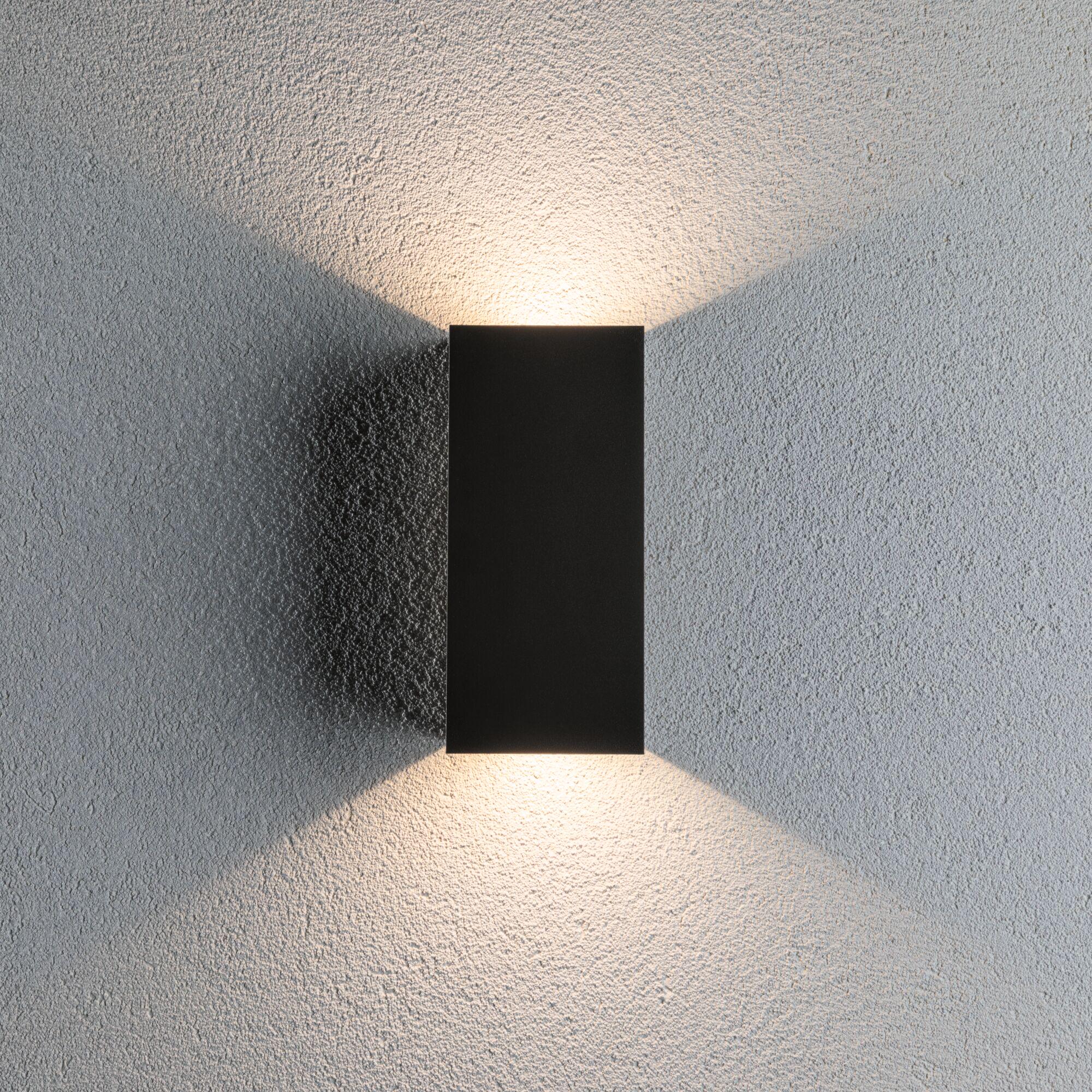 Schwarze Aluminium-Wandleuchte mit warmweißem LED-Licht auf strukturierter grauer Wand für moderne Innenbeleuchtung