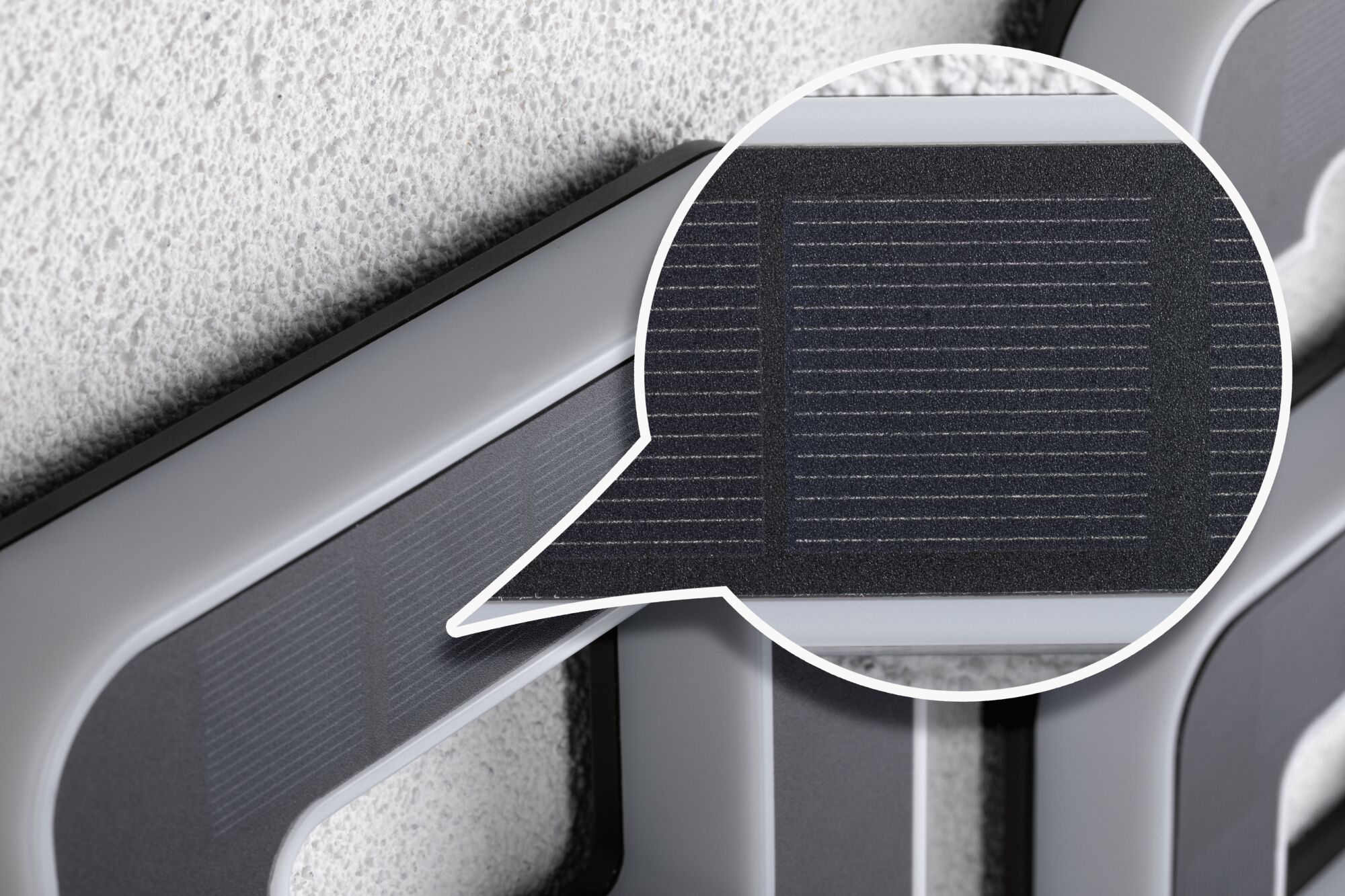 Nærbillede af gråt plastikramme med integreret solpanel til energibesparende belysning