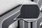 Close-up of grey plastic frame with black textured grid for lighting system components