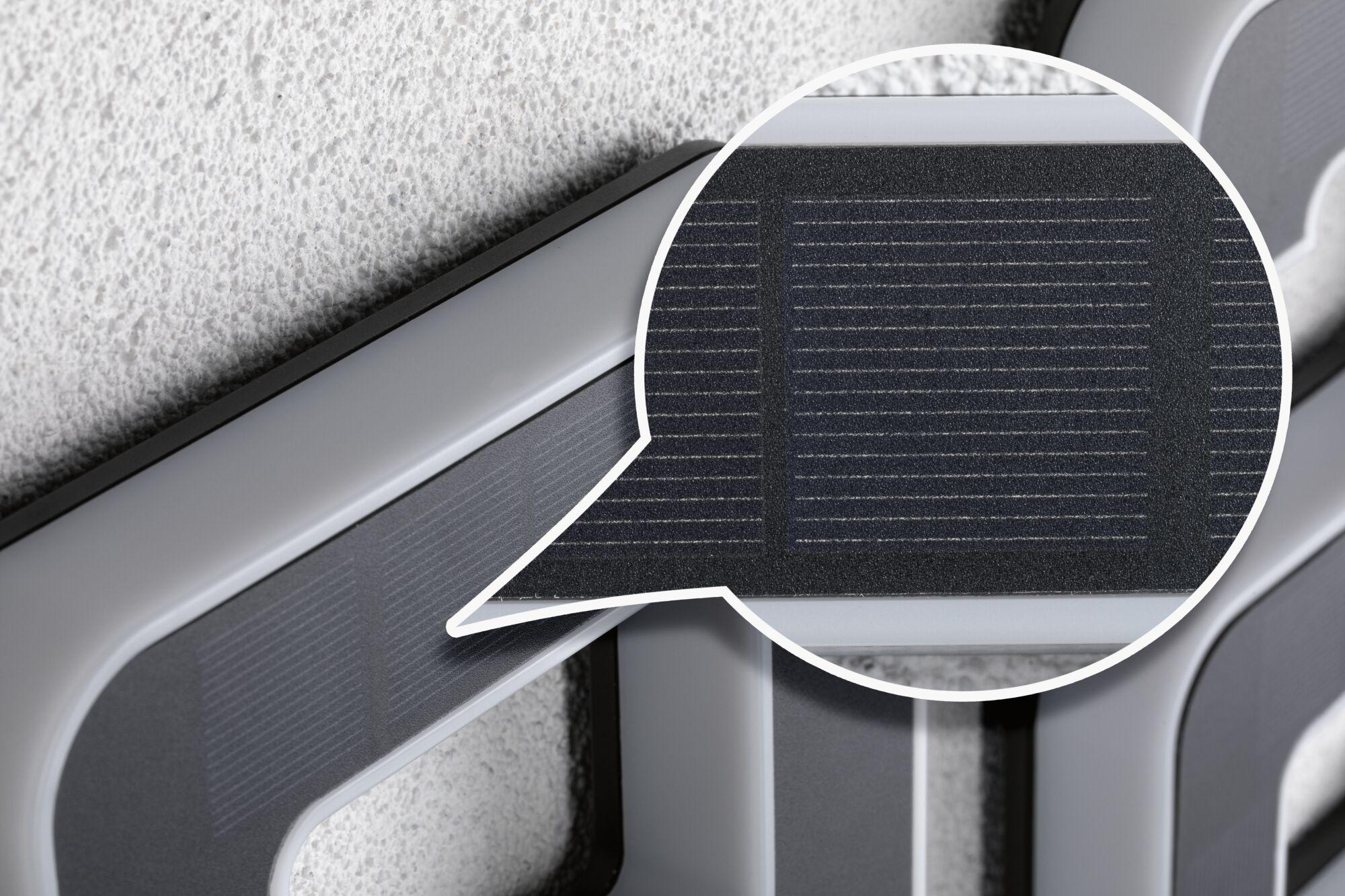 Close-up of grey plastic frame with black textured grid for lighting system components