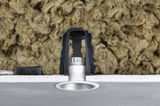 Silver recessed LED spotlight with black bracket and insulation in ceiling cavity for energy-efficient lighting