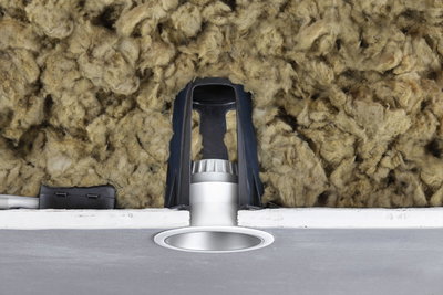 Silver recessed LED spotlight with black bracket and insulation in ceiling cavity for energy-efficient lighting